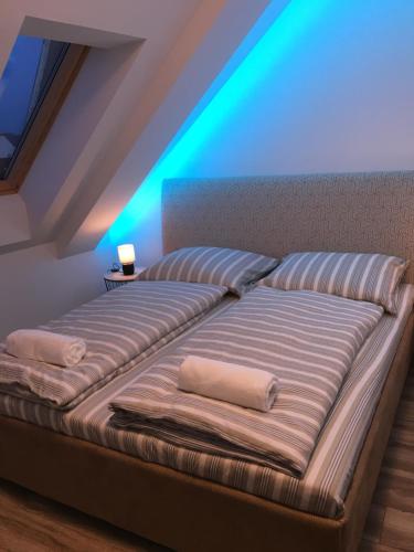 a bed with two pillows on it in a room at Queen Apartman in Debrecen