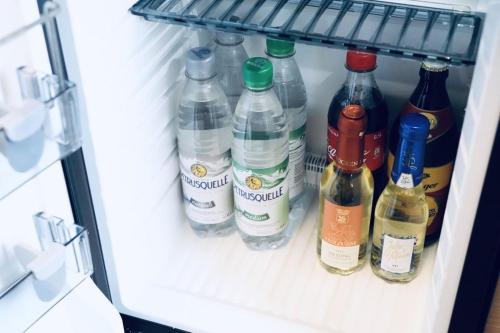 a refrigerator filled with lots of bottles of alcohol at Hotel Garni Möwe am See in Prien am Chiemsee
