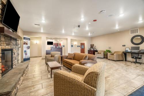 a living room with couches and a fireplace at Cobblestone Inn & Suites - Kermit in Kermit