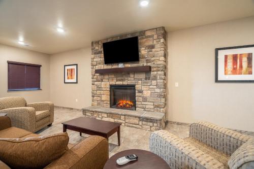 a living room with a fireplace and a tv at Cobblestone Inn & Suites - Kermit in Kermit