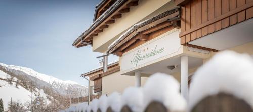 a building with a sign on the side of it at Garni Appartement Alpenresidence in Cadipietra