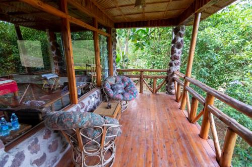 a porch with couches and chairs on a wooden deck at Rushaga Gorilla Lodge in Bugambira