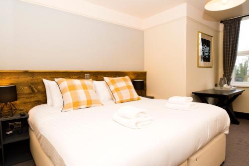 a bedroom with a large white bed with two hats on it at Bowling Green in Manchester