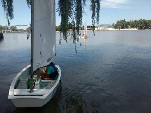 a small boat on the water with a person in it at Cabaña del Río in Villa María