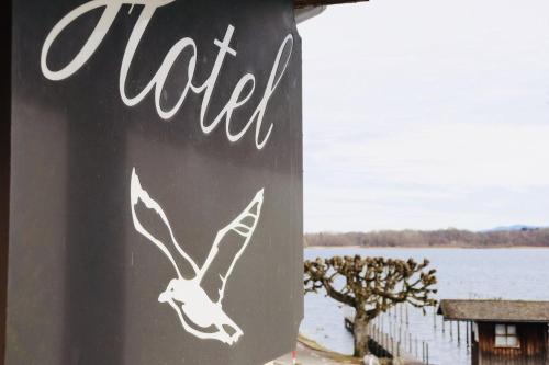 a sign with a bird painted on the side of a pole at Hotel Garni Möwe am See in Prien am Chiemsee