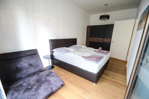 a small bedroom with a bed and a chair at Hochwertig im Herzen Stuttgarts in Stuttgart