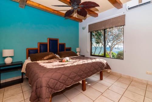 une chambre avec un grand lit avec un mur bleu dans l'établissement Villas Alturas, à Dominical