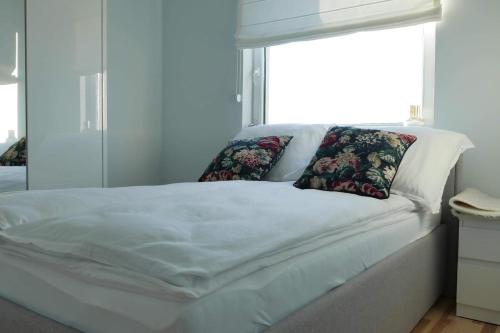 białe łóżko z 2 poduszkami i oknem w obiekcie Apartament Soft 16 w Białej Podlaskiej