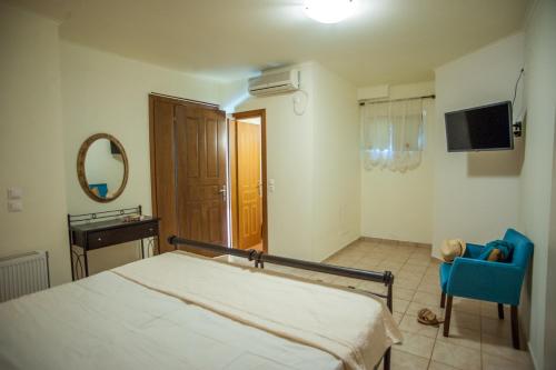 a bedroom with a bed and a chair and a mirror at Evianna Studios in Mousata