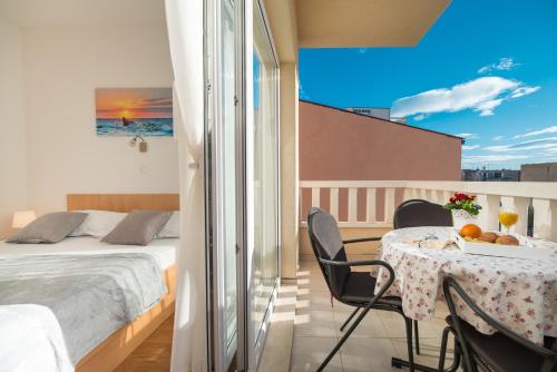 um quarto com uma cama e uma mesa com uma tigela de fruta em Villa Lelas em Makarska