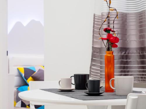 a table with a vase with a red flower in it at Plebiscito Home Holidays in Naples