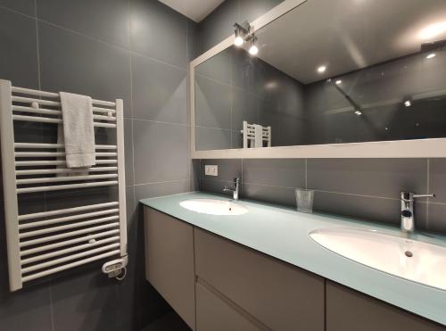 une salle de bain avec deux lavabos et un grand miroir dans l'établissement Très beau T2 dans parc montfleury ,proche centre ,au calme 44 bd Montfleury, à Cannes