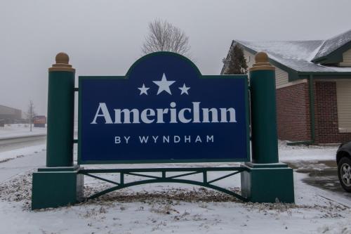 a blue sign for americanitution in the snow at AmericInn by Wyndham Lincoln South in Lincoln