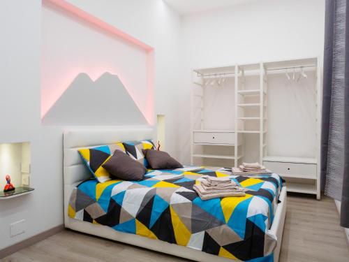 a bedroom with a bed with a colorful blanket at Plebiscito Home Holidays in Naples