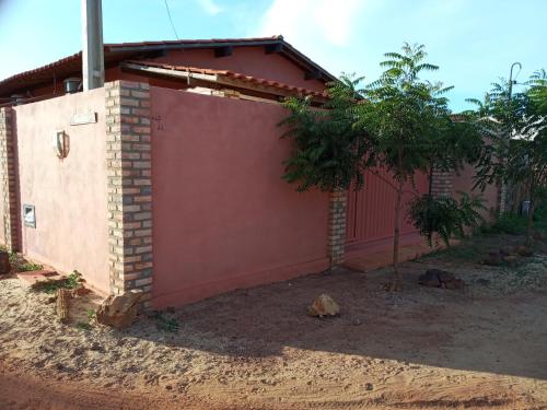 una casa con una pared roja y un árbol en LA MAISON OLIVER SPEEDS, en São Miguel do Gostoso