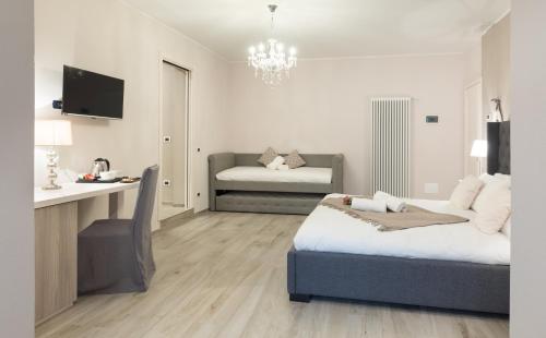 a bedroom with a bed and a couch in it at Residenza Conca Verde B&B la Suite in Rogolo