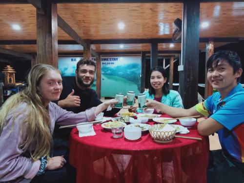 a group of people sitting around a table with drinks at Ba Be Green Homestay in Bak Kan