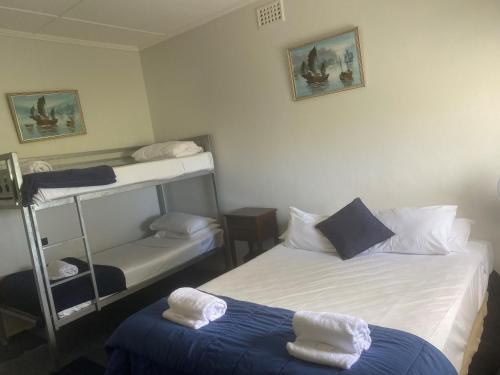 a hotel room with two beds and a toilet at Tin Can Bay Budget Accommodation in Tin Can Bay
