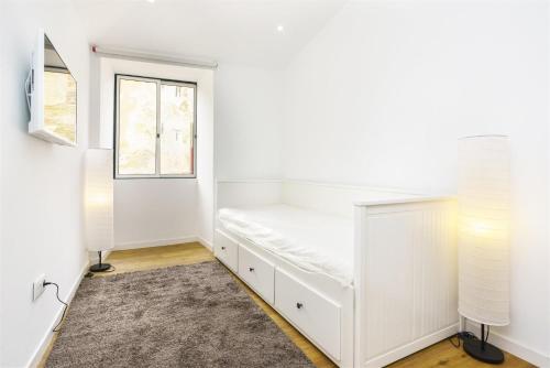 a bedroom with a white bed and a window at Central Lisbon Studio in Lisbon