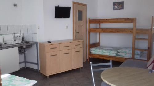 een keuken met een stapelbed en een bureau met een tafel bij Domek u Hermana in Mrzeżyno
