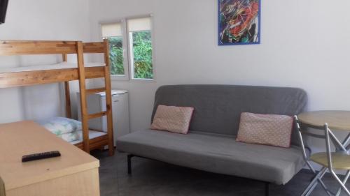 een woonkamer met een bank en een stapelbed bij Domek u Hermana in Mrzeżyno