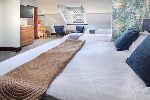 a large white bed in a room with a desk at Park Hotel in Redcar