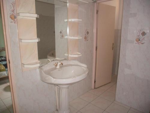 y baño con lavabo blanco y ducha. en Villa Grandes pièces, en Petit-Bourg