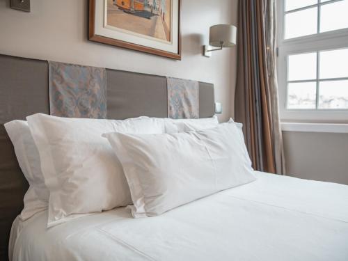 a white bed with a white comforter and pillows at Guest House Douro in Porto
