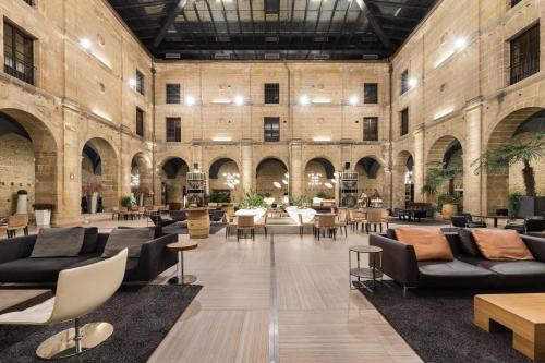 a large lobby with couches and tables and chairs at Eurostars Los Agustinos in Haro