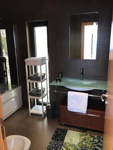 a bathroom with a sink and a counter with a mirror at Luxus Ferienhaus Casa Paraiso in Sesimbra