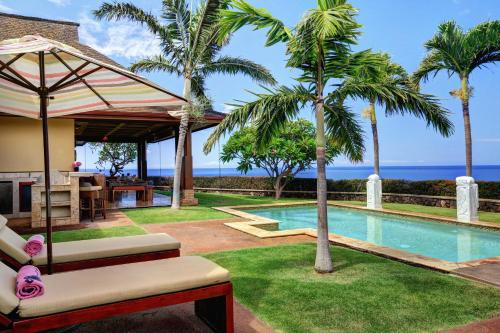a resort with a swimming pool and palm trees at Aloha Spirit Maui home in Lahaina