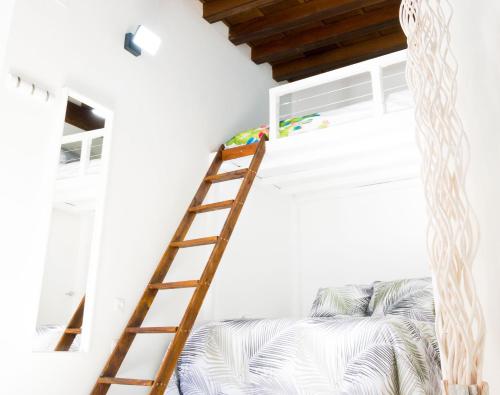 een slaapkamer met een stapelbed en een ladder bij Pasaje de Amores in Sevilla