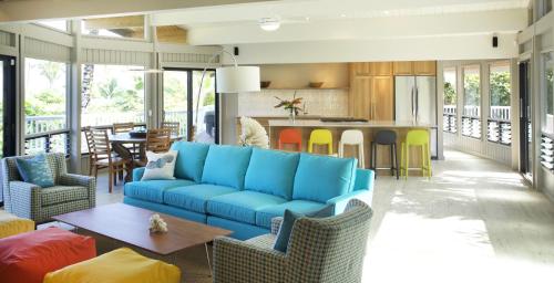 a living room with a blue couch and a kitchen at Haena Kai home in Haena