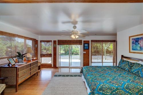 a bedroom with a bed and a ceiling fan at Hale Ki'i Maka Manu home in Keaau