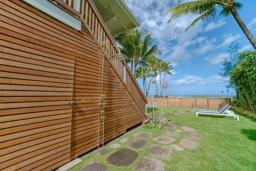 a wooden wall with a bench next to the beach at Hanalei Beach House Estate home in Hanalei