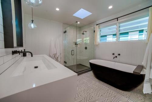 a white bathroom with a tub and a shower at Hanalei Beach House Estate home in Hanalei