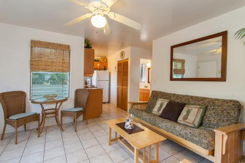 uma sala de estar com um sofá e uma mesa em Malu Kauai, a Beautiful Kauai Cottage 1 Mile from Kalapaki Beach home em Lihue