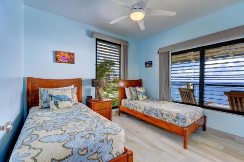 a bedroom with two beds and a window at Poipu Shores 301B condo in Koloa