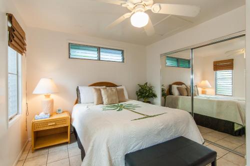 a bedroom with a bed and a mirror at Malu Kauai, a Beautiful Kauai Cottage 1 Mile from Kalapaki Beach home in Lihue