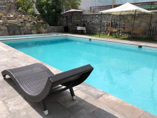 a wicker chair sitting next to a swimming pool at Hotel de Turistas Abancay in Abancay