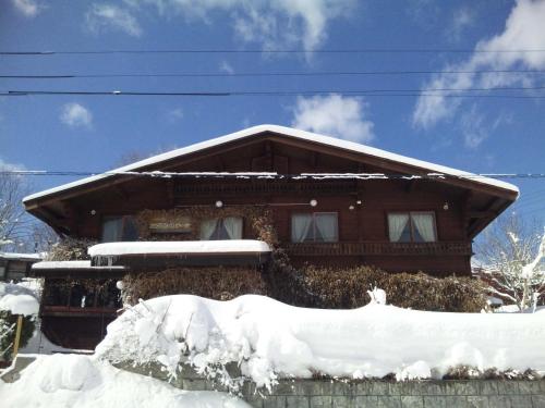 a house covered in snow in front at Yamagata Zao Pension Aplon Stage in Kaminoyama