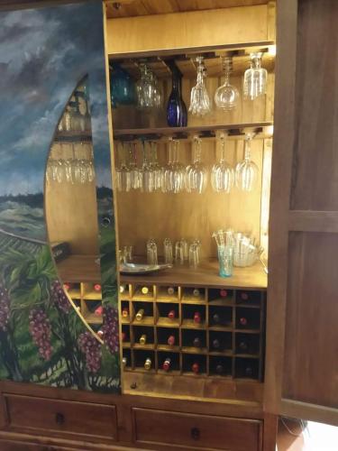 a cabinet filled with wine glasses and a painting at Casa Quintana in San Miguel de Allende