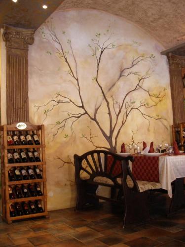 a wall with a painting of a tree on it at Hotel Brilliantin in Sliven