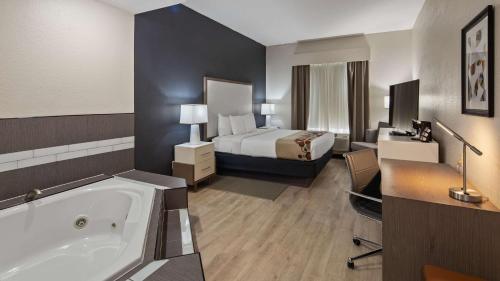 a hotel room with a bed and a bath tub at Best Western Heritage Inn and Suites in Wauchula Hills