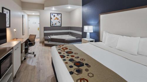 a hotel room with a bed and a bath tub at Best Western Heritage Inn and Suites in Wauchula Hills