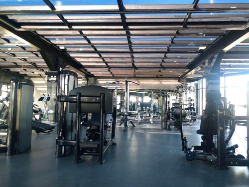 a gym with several treadmills and machines in it at Livefortuna Hotel in Beijing