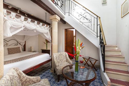 a bedroom with a bed and a stairway with a table at Viva Merida Hotel Boutique in Mérida