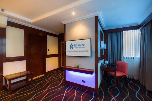 a hotel room with a red chair and a desk at Cebu Parklane International Hotel in Cebu City
