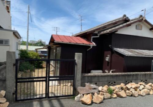a black gate in front of a house at Engawa in Tonosho