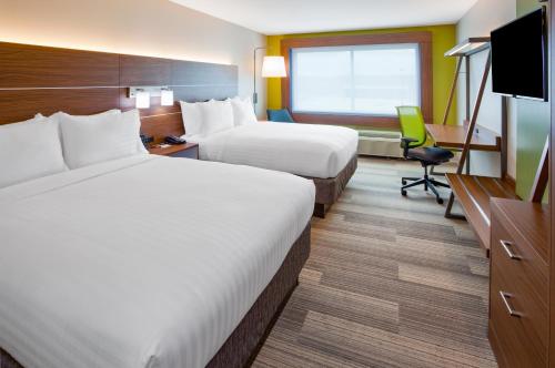 a hotel room with two beds and a desk at Holiday Inn Express and Suites Des Moines Downtown by IHG in Des Moines